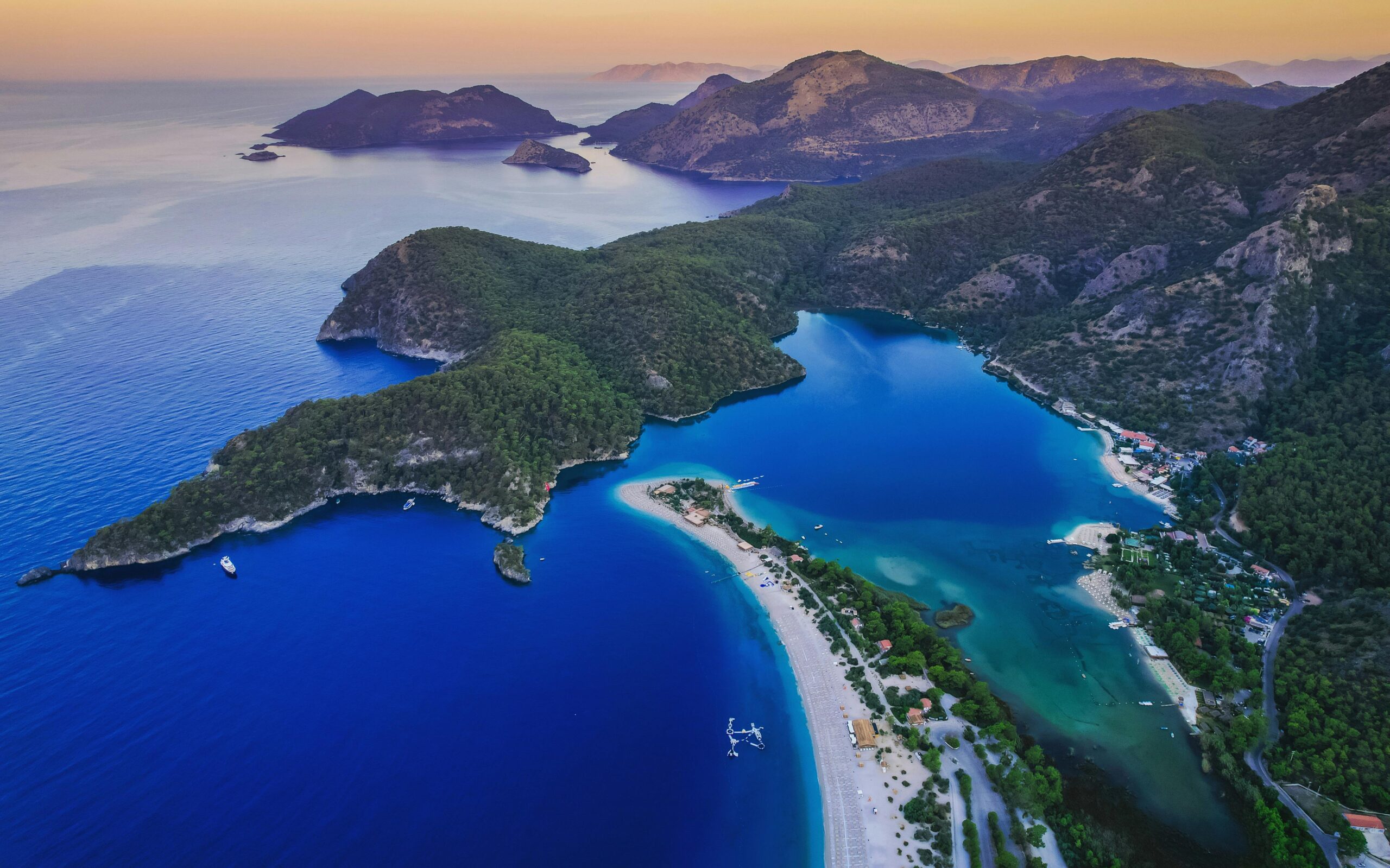 Aerial shot of a peaceful island with blue water and lush greenery.